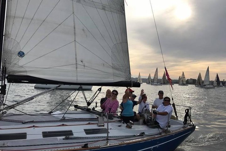 Group sailing on boat during sunset race