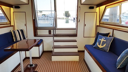 Boat cabin interior with blue seating and wooden floor