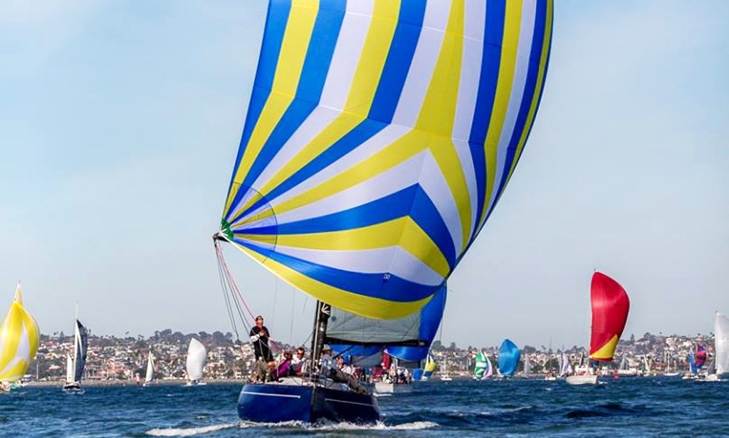Sailboats racing with colorful spinnaker sails on water