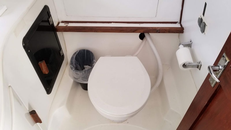 Small boat bathroom with toilet and trash can
