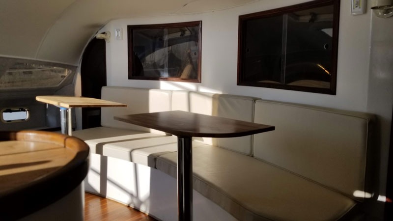 Cozy yacht interior with white seating and tables