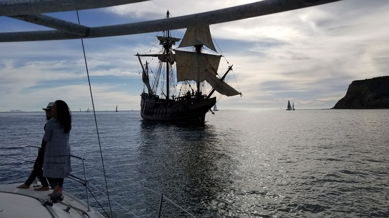 People watching a sailing ship on the ocean