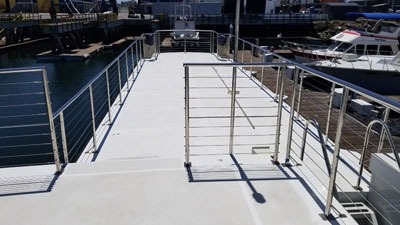 Boat dock walkway with safety railings by water