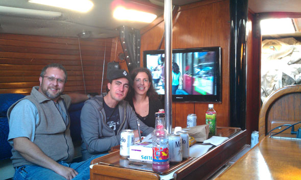 People relaxing inside a boat cabin with drinks