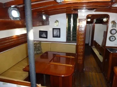 Wood-paneled yacht interior with seating and table.