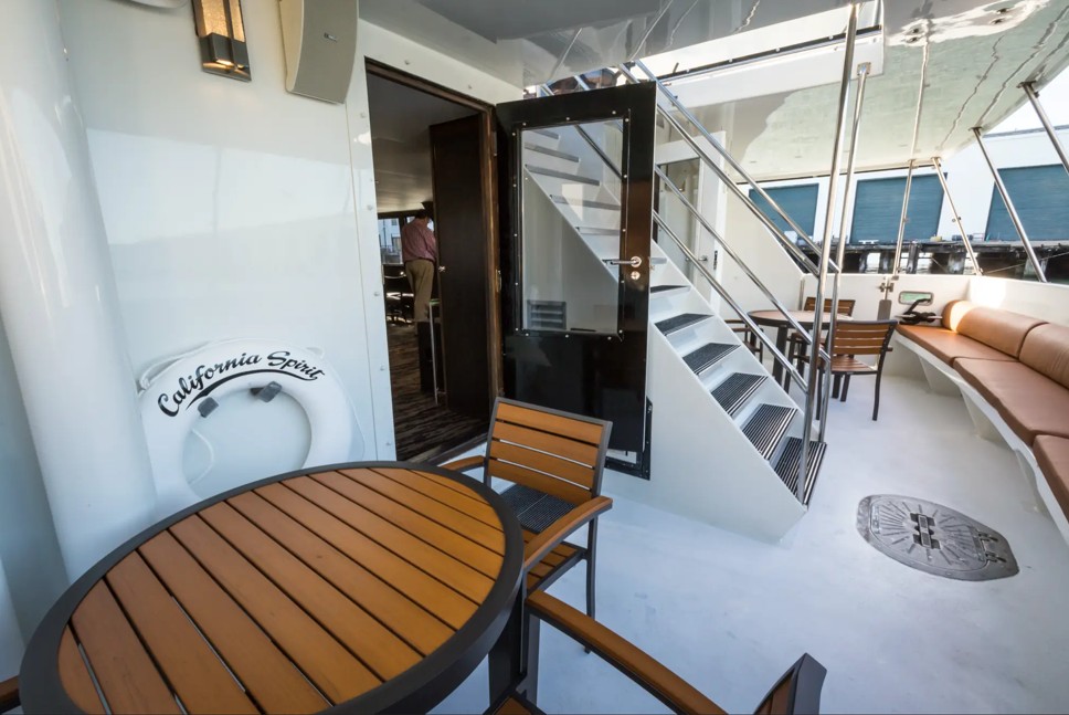 100_luxury_yacht_pacifica3 Outdoor yacht deck with wooden seating area.